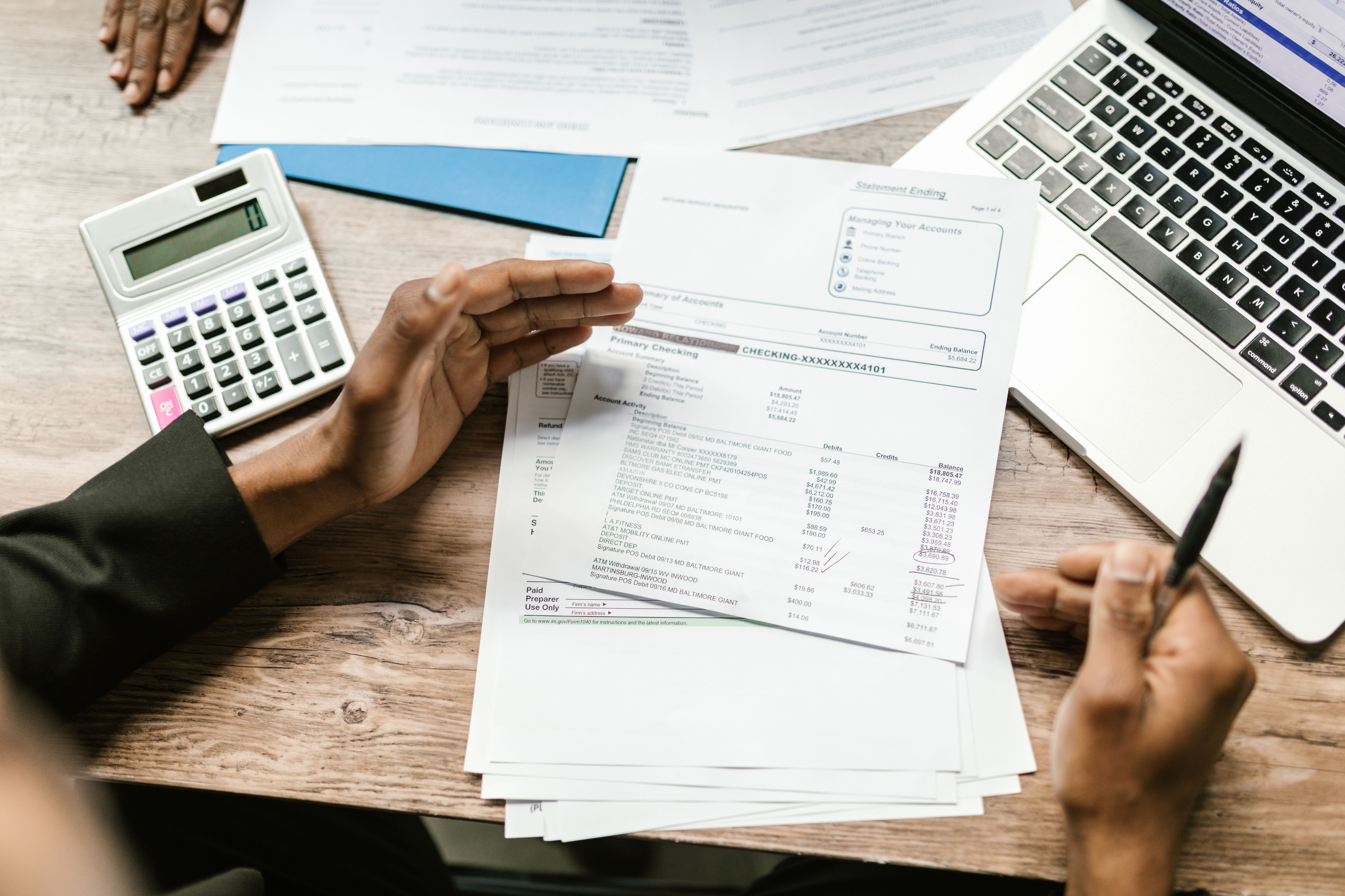 Personas revisando informes y documentación para descargar programas de ayuda fiscal